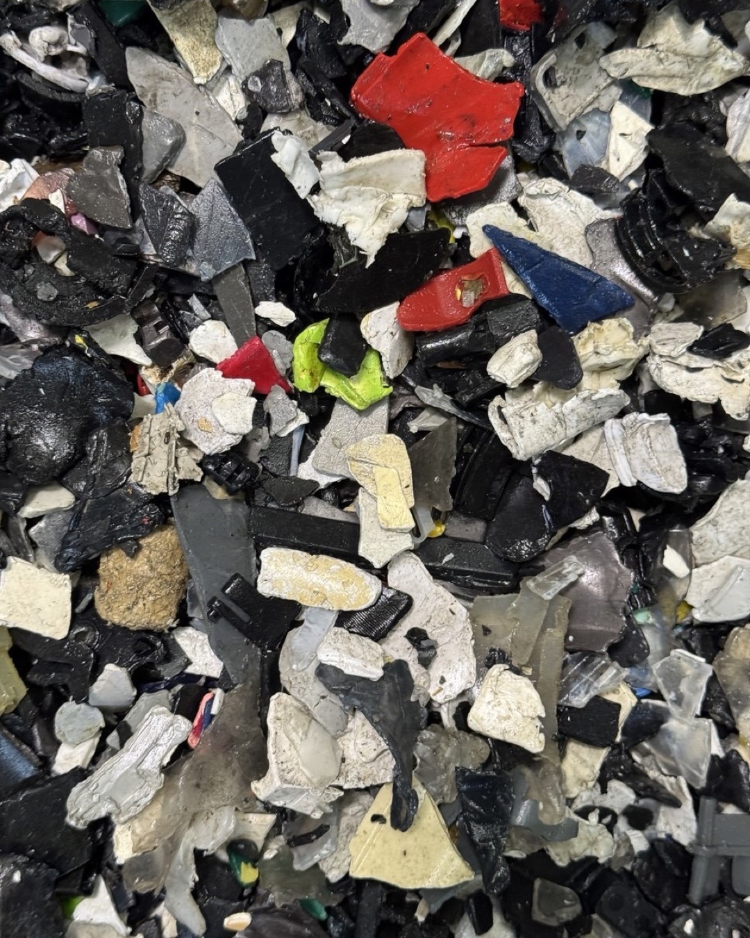 Shredded plastic from end-of-life electronics — a mix of clean polymer and fragments carrying persistent organic pollutants.